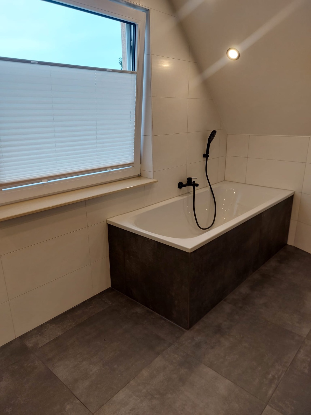 Freistehende Badewanne mit anthrazitfarbener Verkleidung