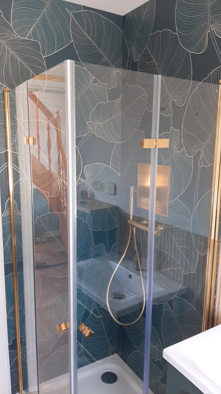 Dusche mit Blättermotiv und goldenen Beschlägen