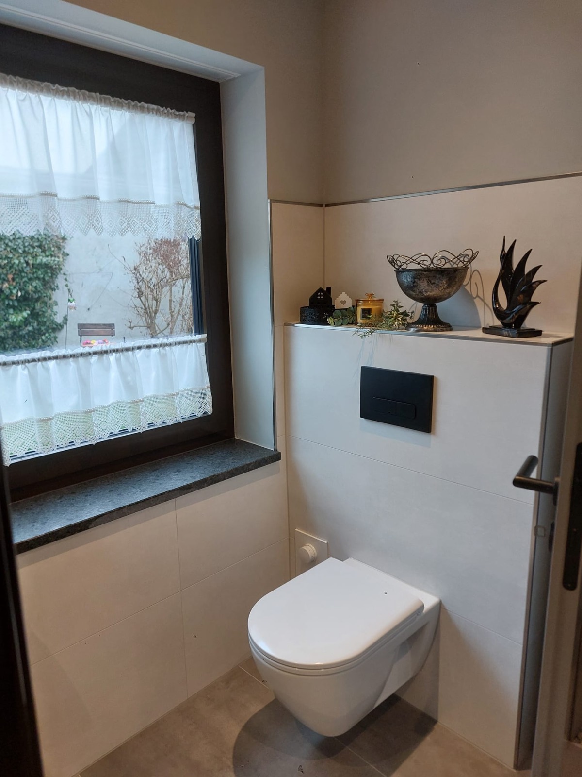 Gäste-WC mit Fenster und dekorativen Accessoires