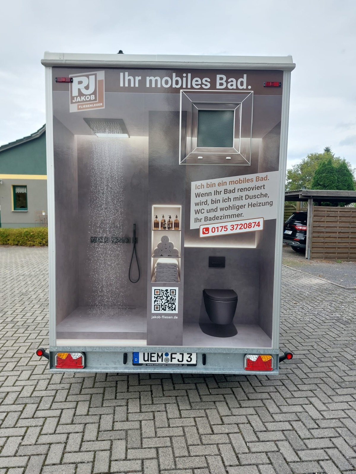 Rückansicht des mobilen Bad-Anhängers mit Beschriftung