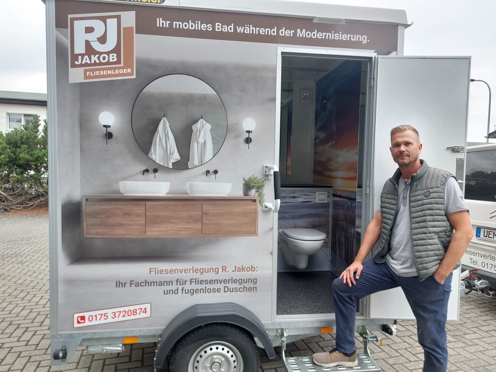 Reimund Jakob vor dem mobilen Bad auf dem Anhänger